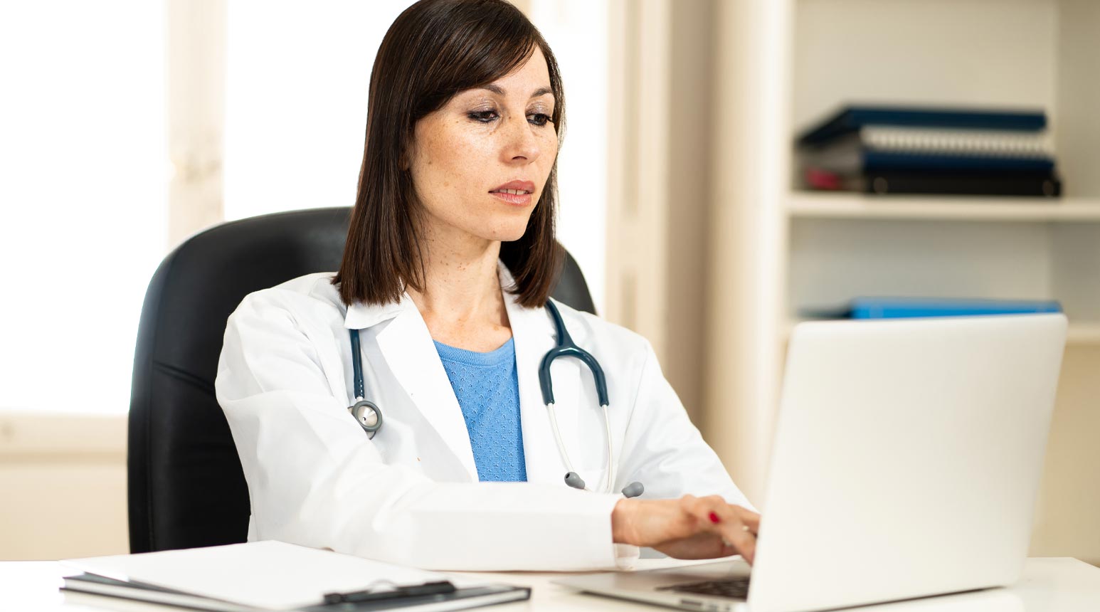 A medical professional at a computer.